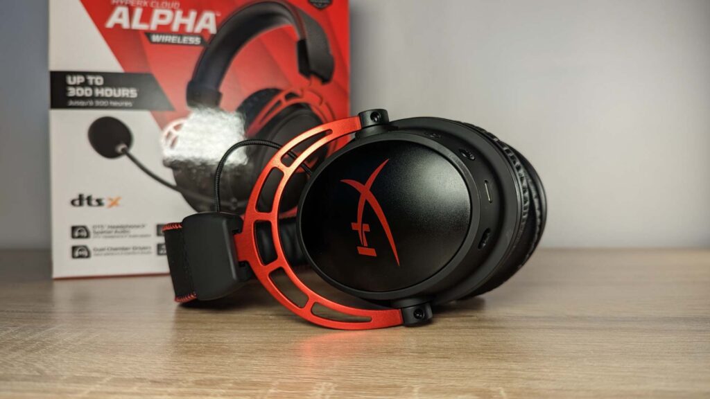 Photo of the HyperX Cloud Alpha Wireless on its side. The red and white HyperX box can be seen in the background.