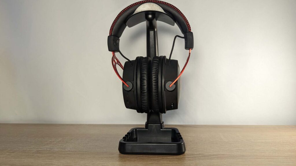 Photo of the HyperX Cloud Alpha Wireless front-on, on a black headphone stand.