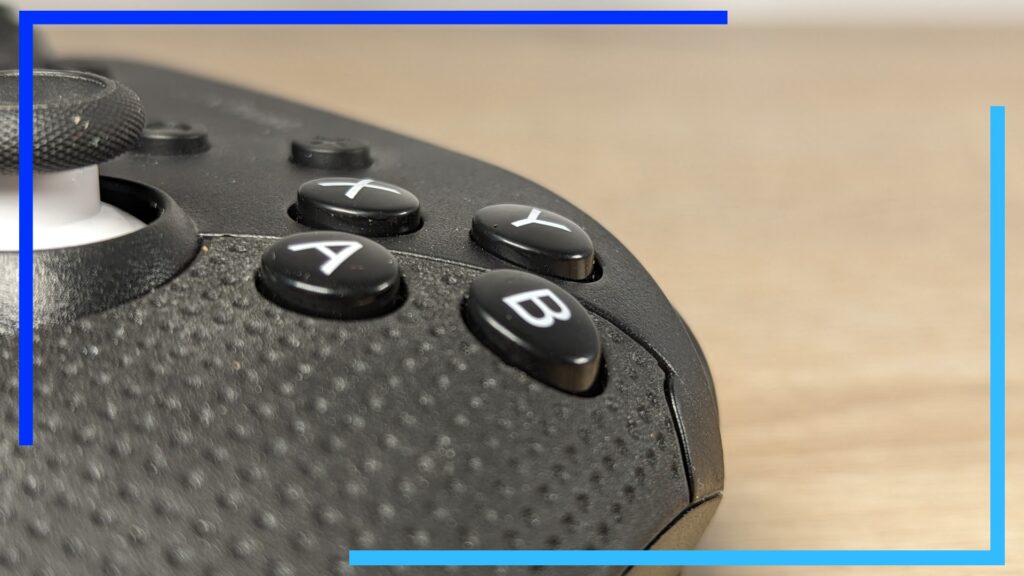 Close-up photo of the black Muta controller's face buttons, also in black, with white lettering on top.