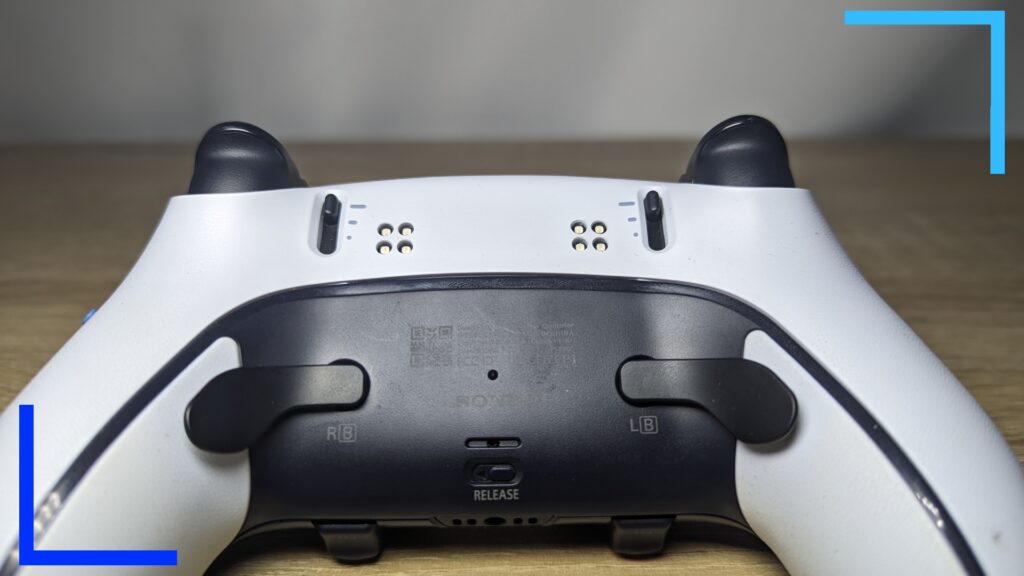 Close up photo of my MegaModz controller in white showing the two black back paddles and the two-by-two cutout section where the lights are.