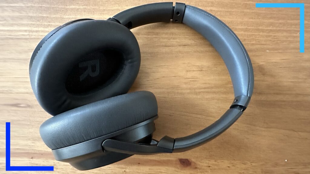 Close-up photo of the Monoprice BT-600ANC headphones, in black, on an oak desk.