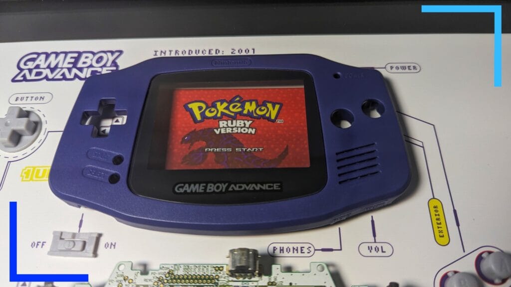 Close up photo of the purple front shell of a Game Boy Advance, with a picture of Pokemon Red behind the screen.