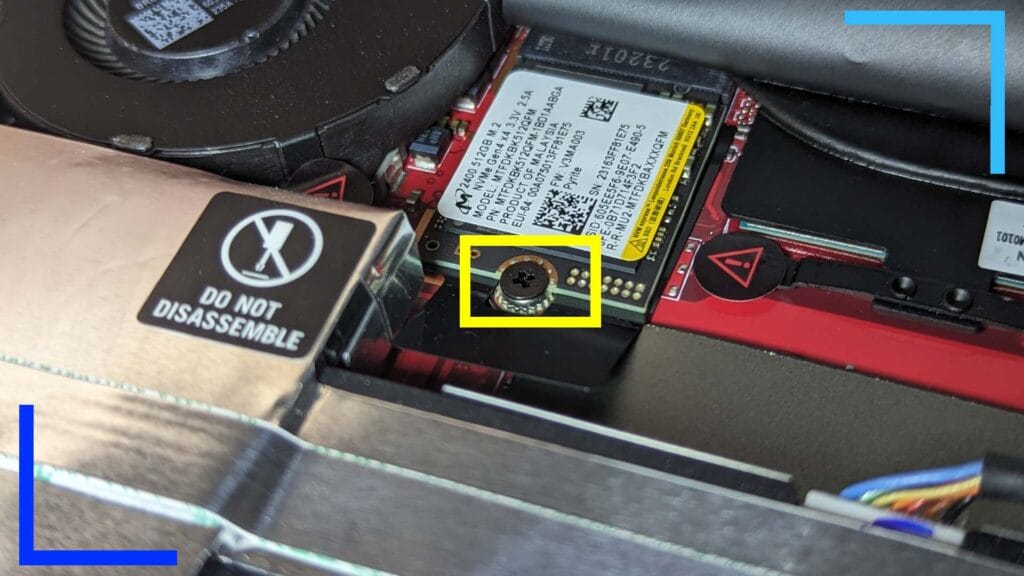 Close up of the original ROG Ally SSD in place with a yellow rectangle over the screw to release it.