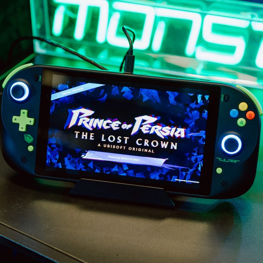 Close up of the blue colored Tulpar handheld with Prince of Persia on the screen.