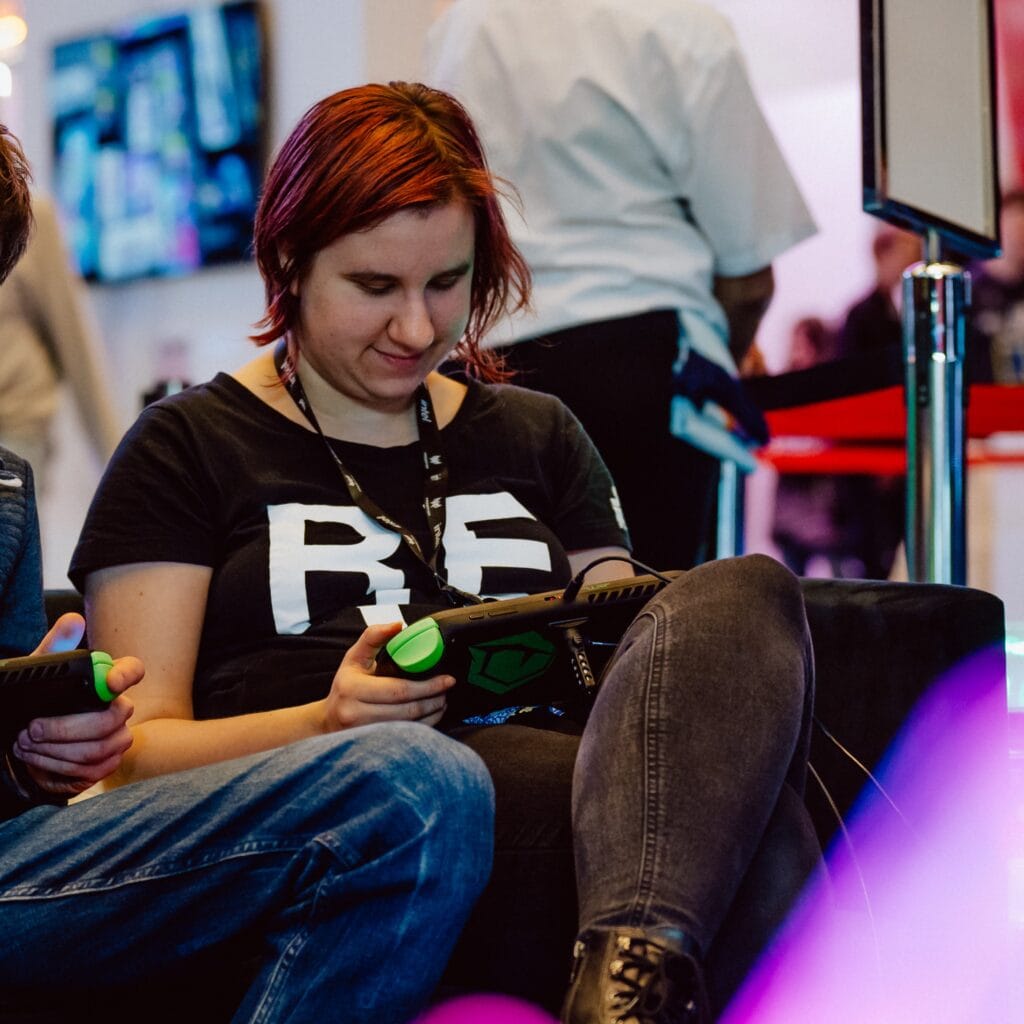 A front shot of a red haired woman playing on the handheld.